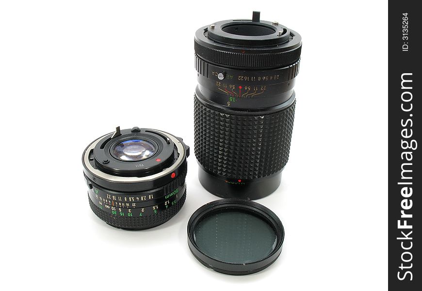 A Pair of 35mm film camera lenses and a screw on lens filter. Photography tools.
