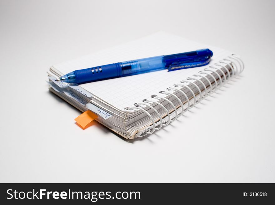 Pen and notebook isolated on grey