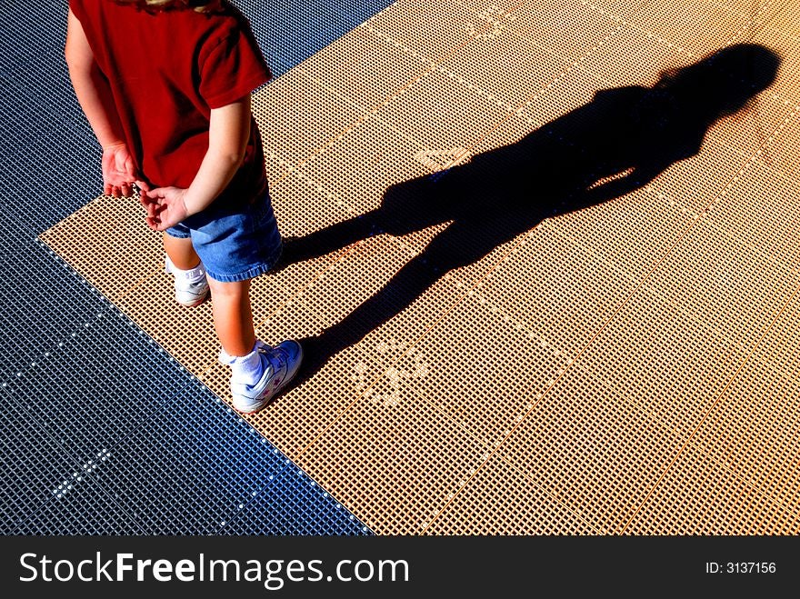 Little girl in red shirt playing hopscotch