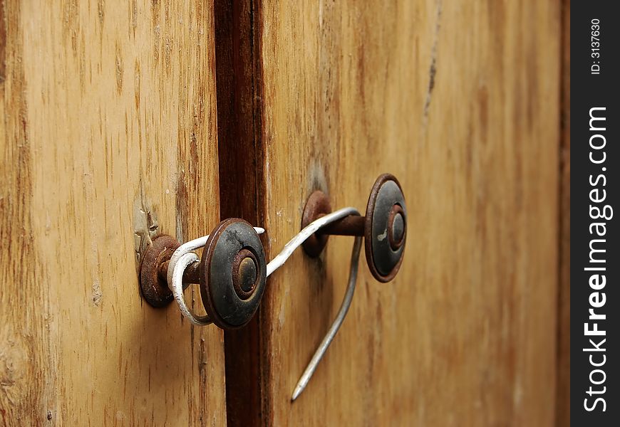 Bad lock made of wire on the wooden doors. Bad lock made of wire on the wooden doors