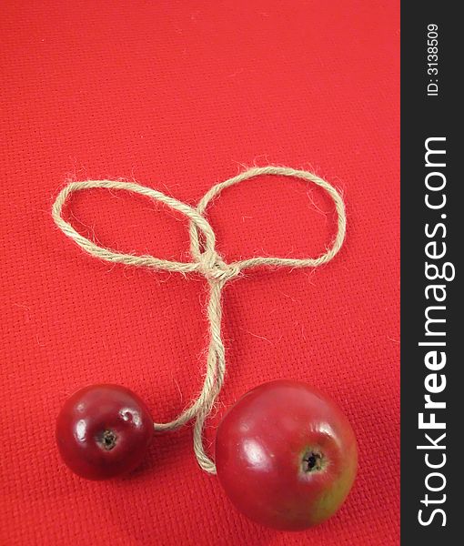 Red apple and string on red ti