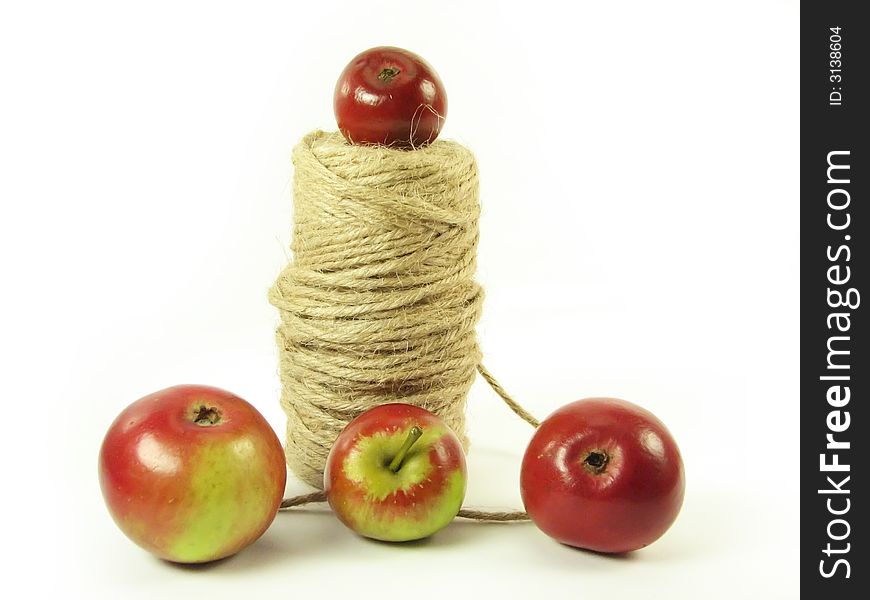 Composite: red apples and string on white background