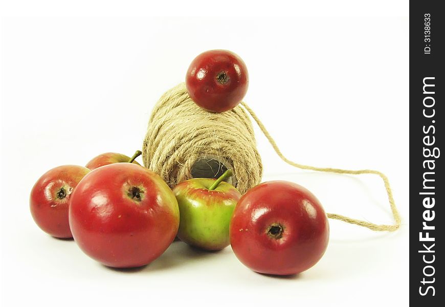 Composite: red apples and string on white background