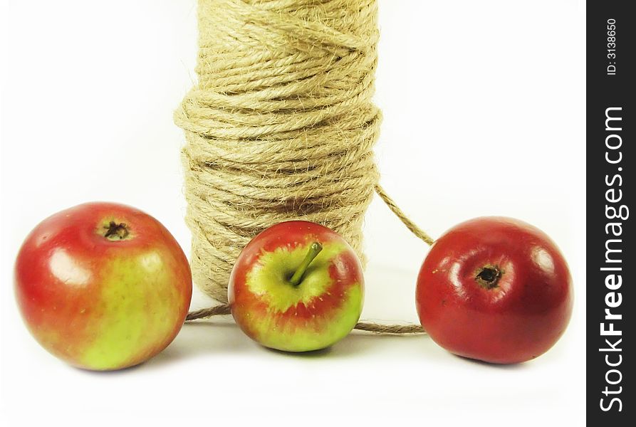 Composite: red apples and string on white background