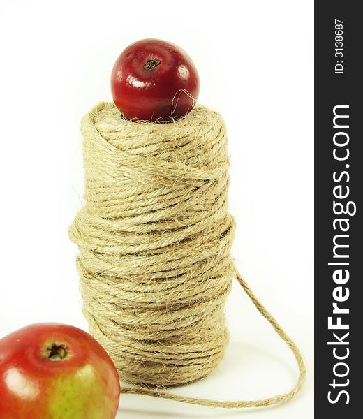 Composite: red apples and string on white background