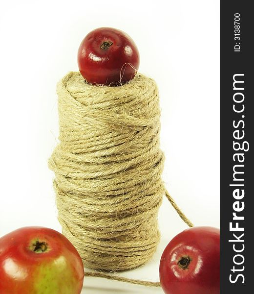 Composite: red apples and string on white background