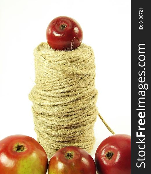 Composite: red apples and string on white background