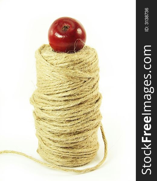 Composite: red apple and string on white background