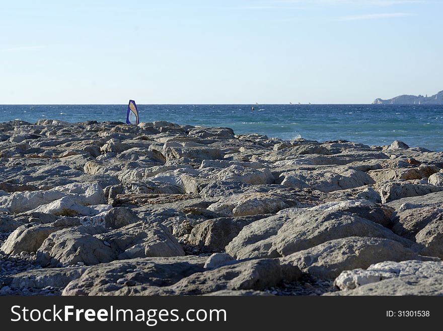 Surfer on the seaside, along a rocky coastline. France, mediterranean coast.