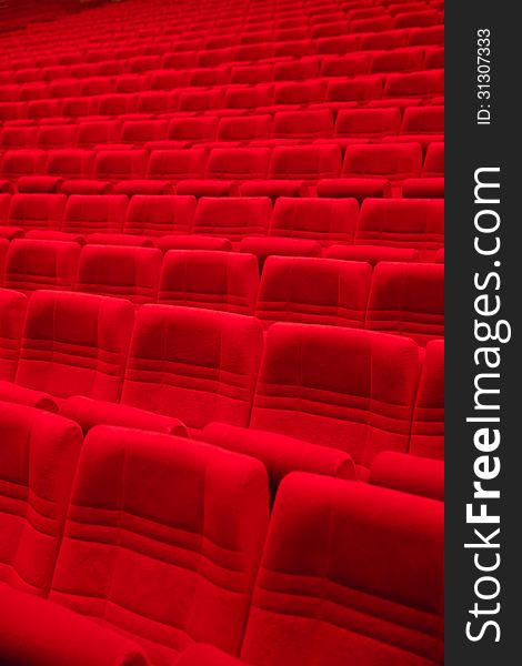 Rows of red arm-chairs in empty hall