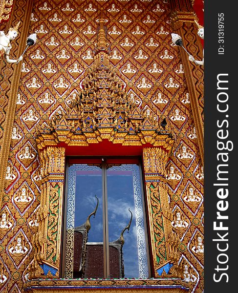 Beautiful window of Thai temple with reflected in the glass on bright blue days
