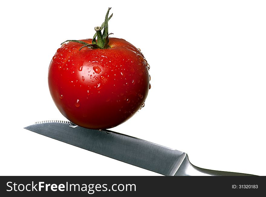 Red tomato on a knife. Red tomato on a knife