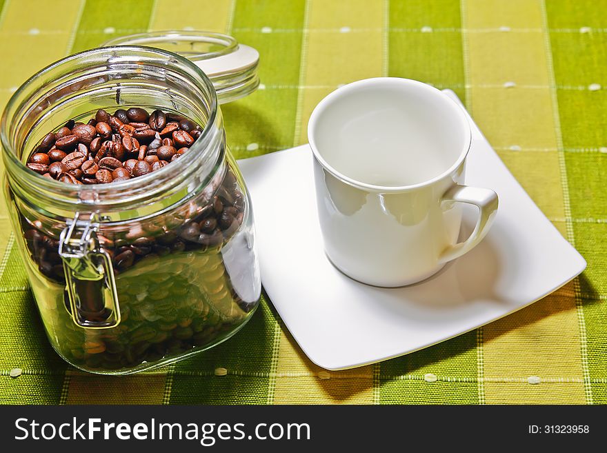 Coffee beans with white cup empty on the table