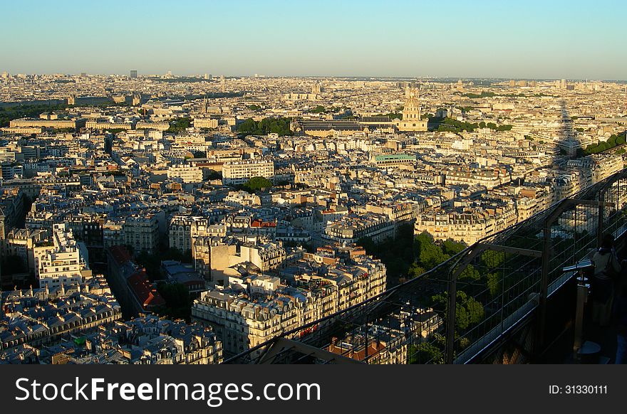 Sunset aerial view of Paris from the Eiffel tower with its shadow projecting over the city