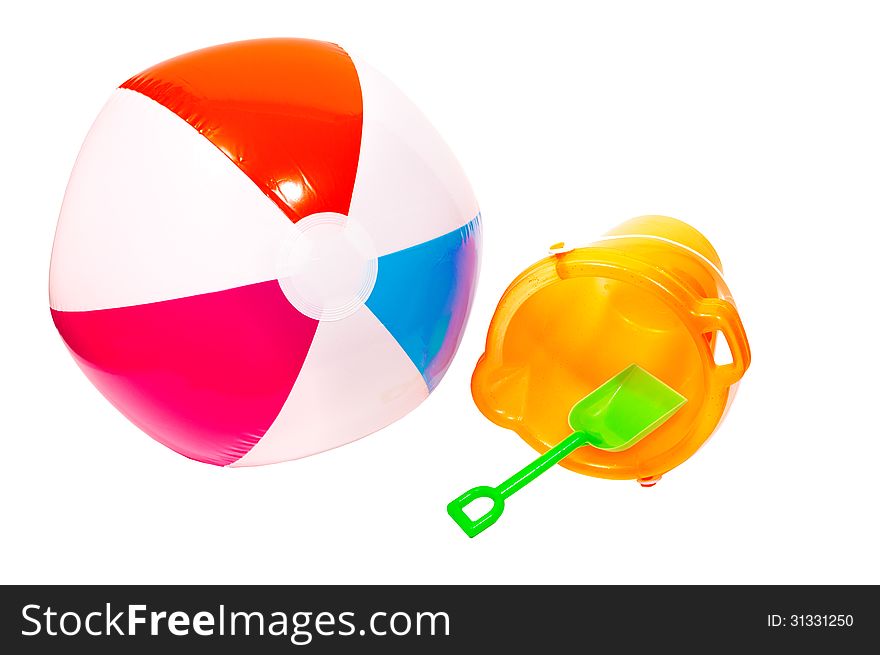 Beach ball and sand pail ready to take to the beach on vacation. Horizontal shot, isolated on a white background. Beach ball and sand pail ready to take to the beach on vacation. Horizontal shot, isolated on a white background