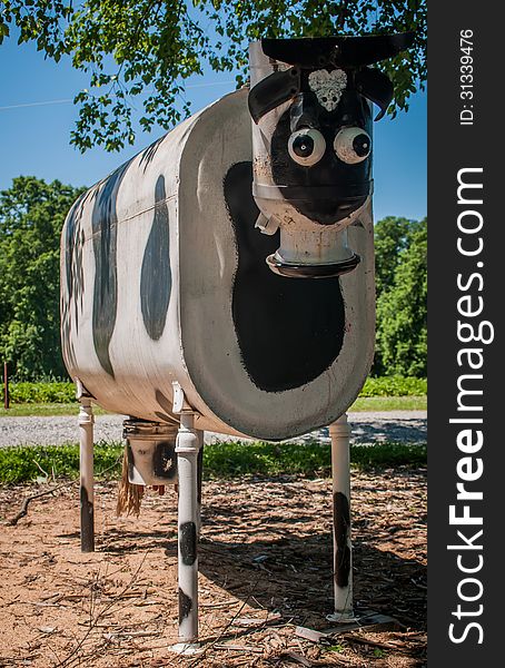 Cow made of metal oil tank on the farm land. Cow made of metal oil tank on the farm land