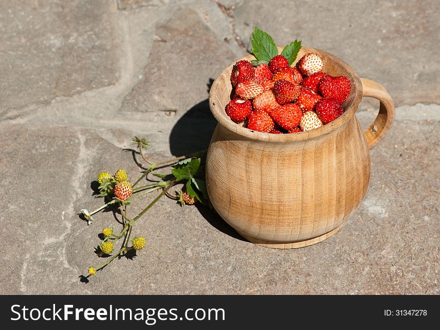The pot of strawberry on a stone. The pot of strawberry on a stone