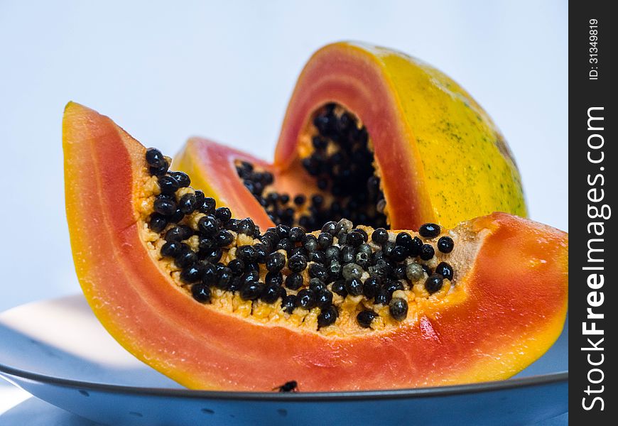 Pieces of papaya with orange flesh and black seeds.