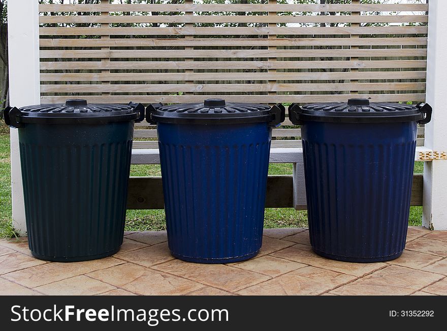 Three waste containers in the street.