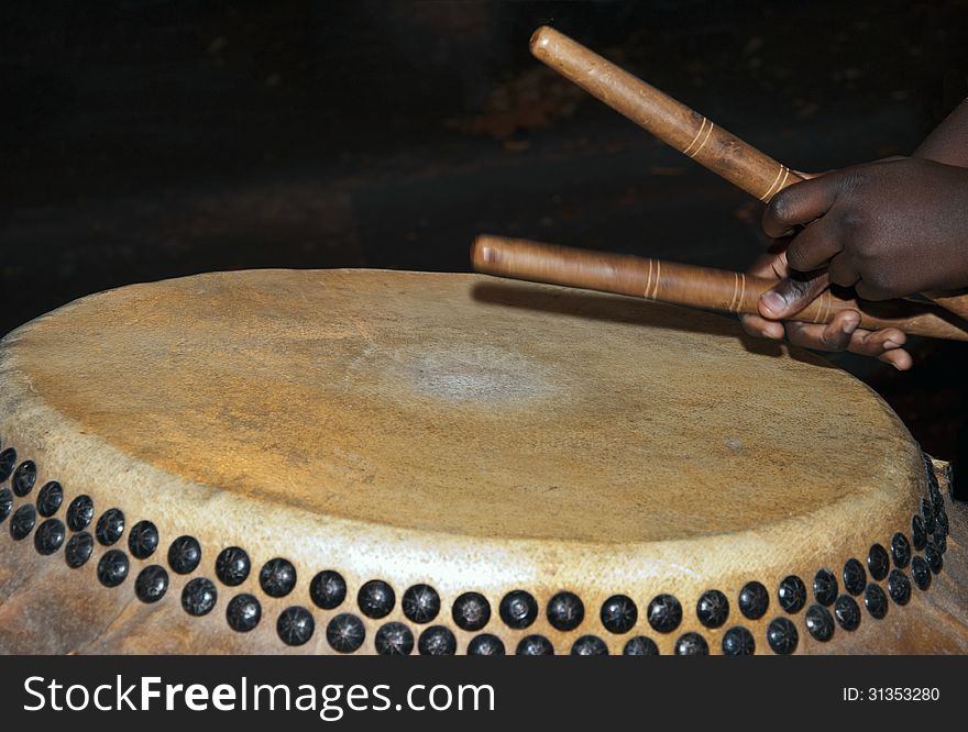 Close up of drummer's hands holding brown wooden sticks and playing a Chinese Drum. Close up of drummer's hands holding brown wooden sticks and playing a Chinese Drum