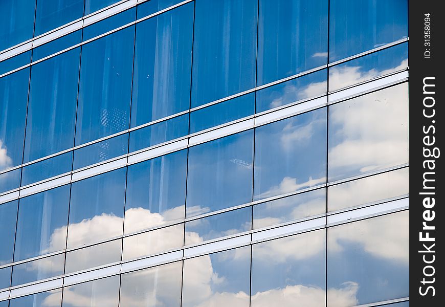 Clouds reflected in windows of modern office building