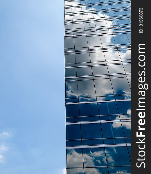 Clouds reflected in windows of modern office building