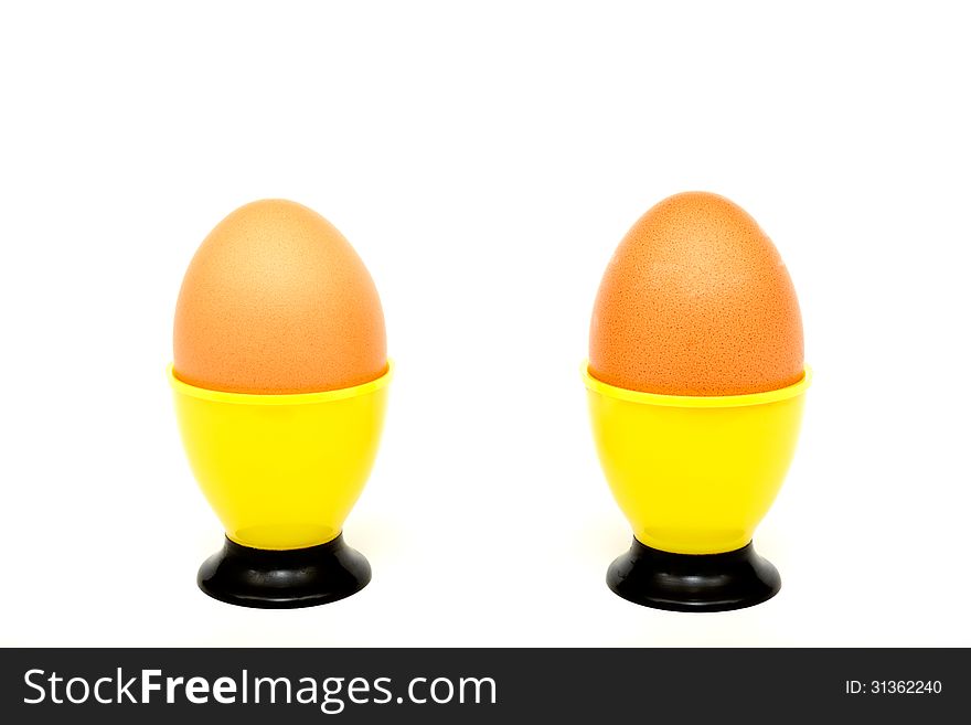 Eggs in a yellow cup on a white background. Horizontal position. Eggs in a yellow cup on a white background. Horizontal position.