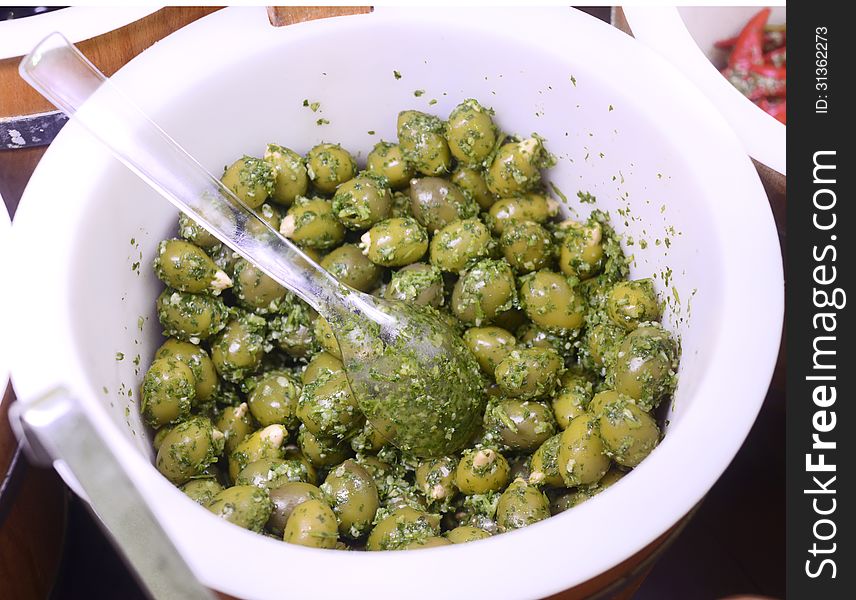 A bowl of fresh green olives with oil, garlic and herbs. Its an italian starter meal.