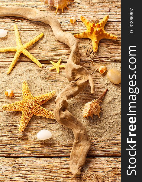 Starfish and shells on wood with sand. Starfish and shells on wood with sand