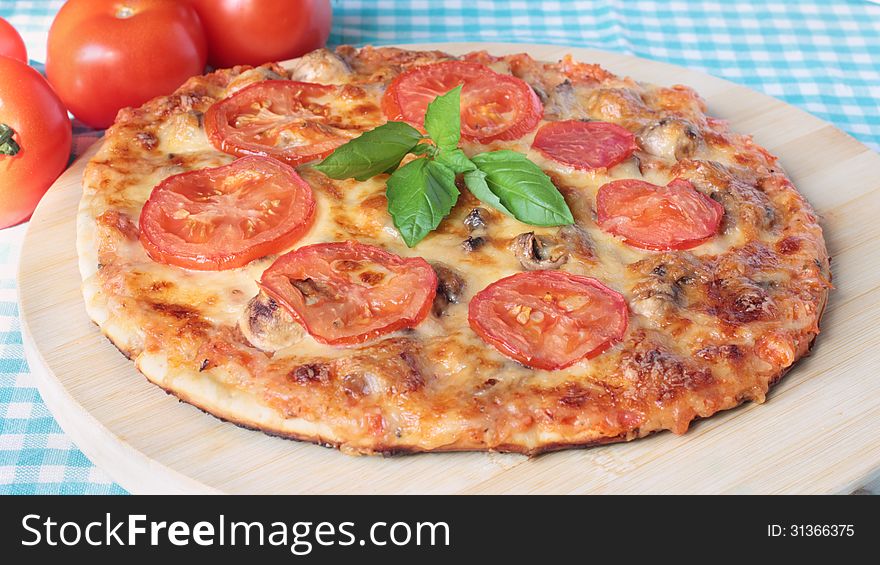 Tasty vegetarian pizza with cheese, tomatoes and champignons