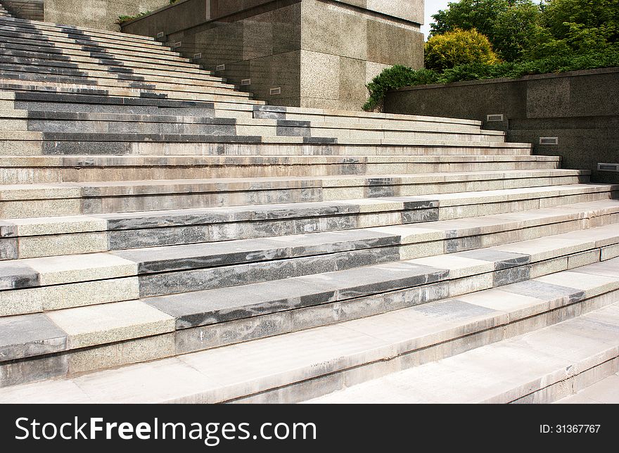 High granite staircase withgreen trees on summer day