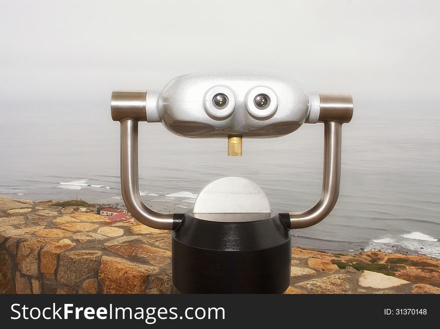 A futuristic looking alien styled travelers binocular magnifying scope vendor device shows through the fog overlooking the Pacific Ocean near San Diego, California, United States. A futuristic looking alien styled travelers binocular magnifying scope vendor device shows through the fog overlooking the Pacific Ocean near San Diego, California, United States