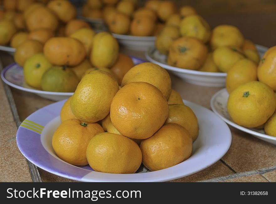 Many of the citrus fruits in a dish on the table. Many of the citrus fruits in a dish on the table