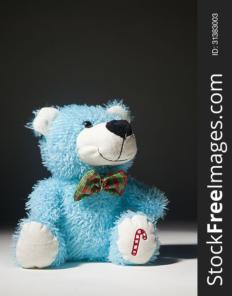 A Blue toy bear looking up against a black background. A Blue toy bear looking up against a black background