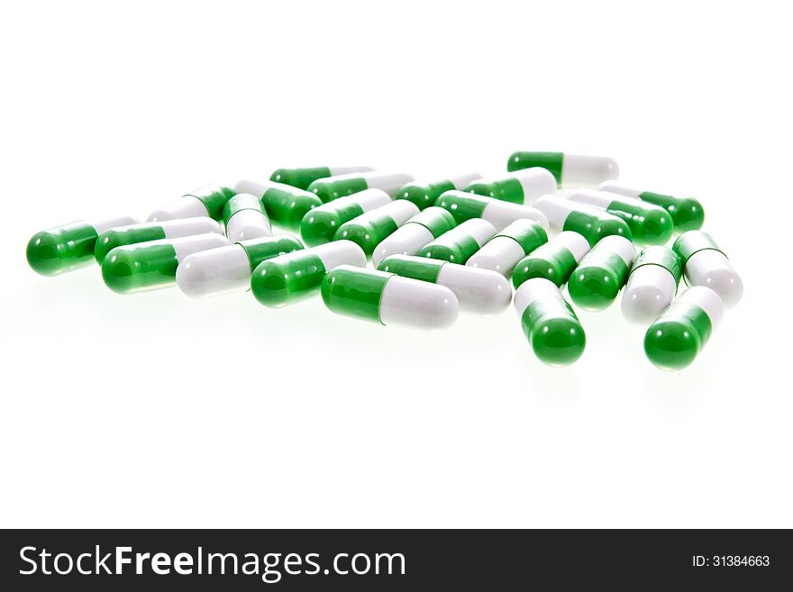 White and green capsule pills isolated on a white background.