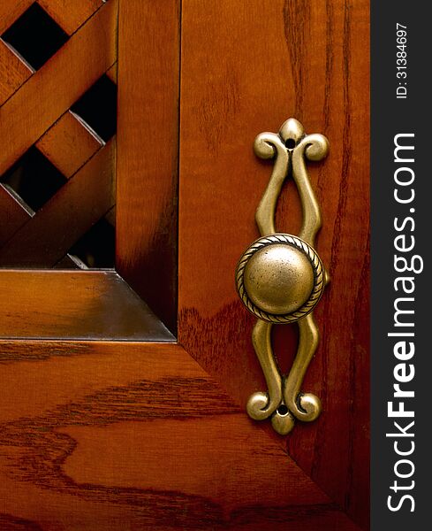 Cupboard wood door. Focus on old-fashioned doorhandle. Cupboard wood door. Focus on old-fashioned doorhandle.