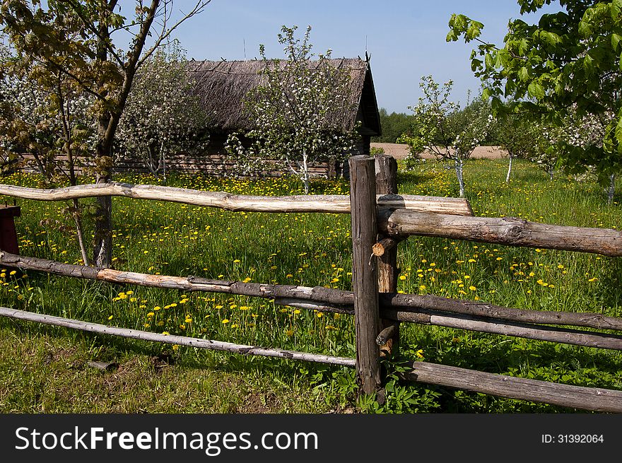 A wooden fence near the old village house. Belarusian wooden architecture of the 19th century. A wooden fence near the old village house. Belarusian wooden architecture of the 19th century.