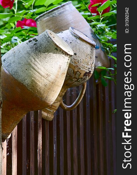 Old clay jugs on a rustic fence. Old clay jugs on a rustic fence