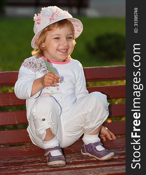 Portrait of the girl in park on a bench.