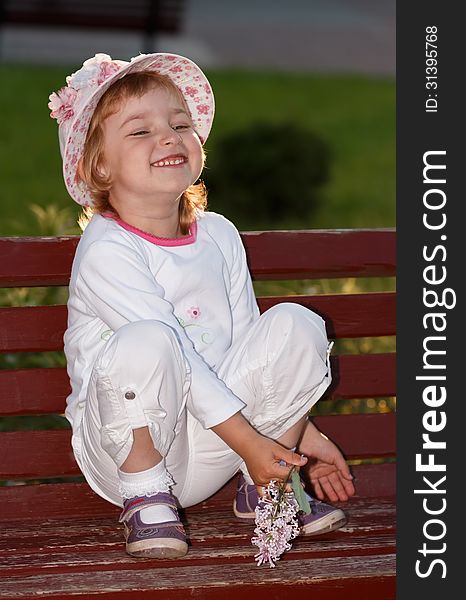 Portrait of the girl in park on a bench.