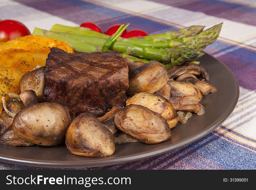 Grilled beef steak plate with mushrooms and asparagus. Grilled beef steak plate with mushrooms and asparagus