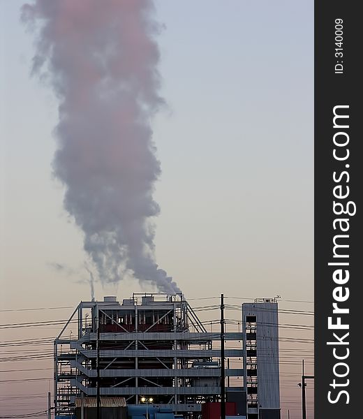 Smoke/Steam rising in a single plume from a power generating station - sunrise light - copy space down right side. Smoke/Steam rising in a single plume from a power generating station - sunrise light - copy space down right side.