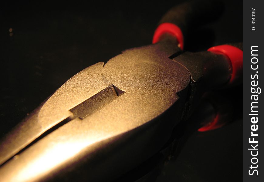 Metallic shining nippers on the black background.