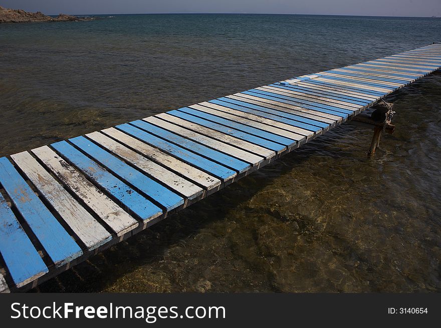 A white and blue plank to the sea. A white and blue plank to the sea