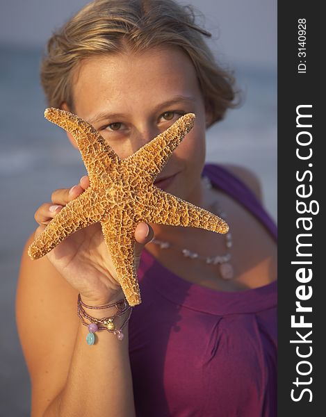 Cute girl is holding up an seastar. Cute girl is holding up an seastar