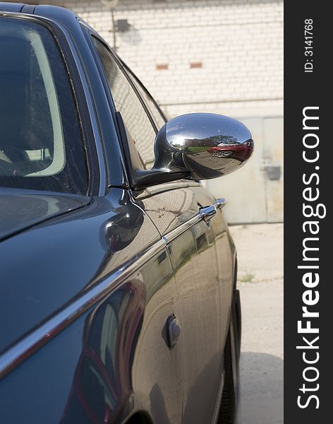 The dark blue machine locate on parking. Reflection from the convex chrome-plated mirror is well visible. The dark blue machine locate on parking. Reflection from the convex chrome-plated mirror is well visible.