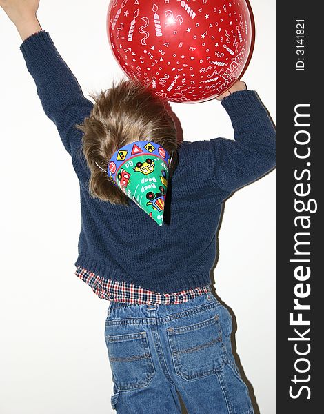 Birthday boy reaching up for balloon