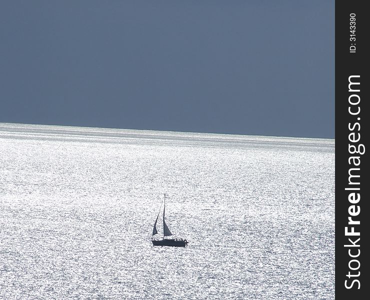 Sailing boat on sea lit up by sun. Sailing boat on sea lit up by sun