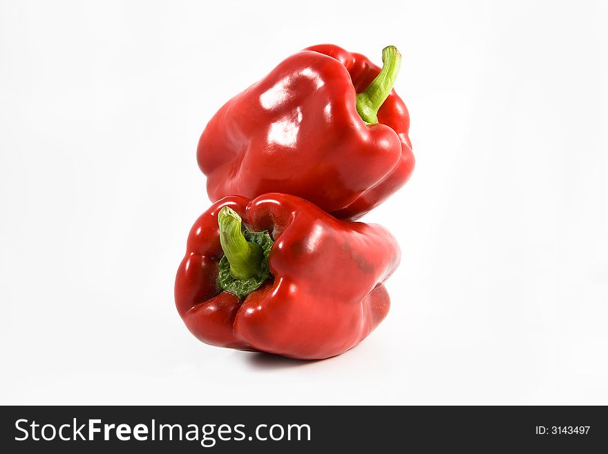Two red Mediterranean peppers one on other one. Two red Mediterranean peppers one on other one