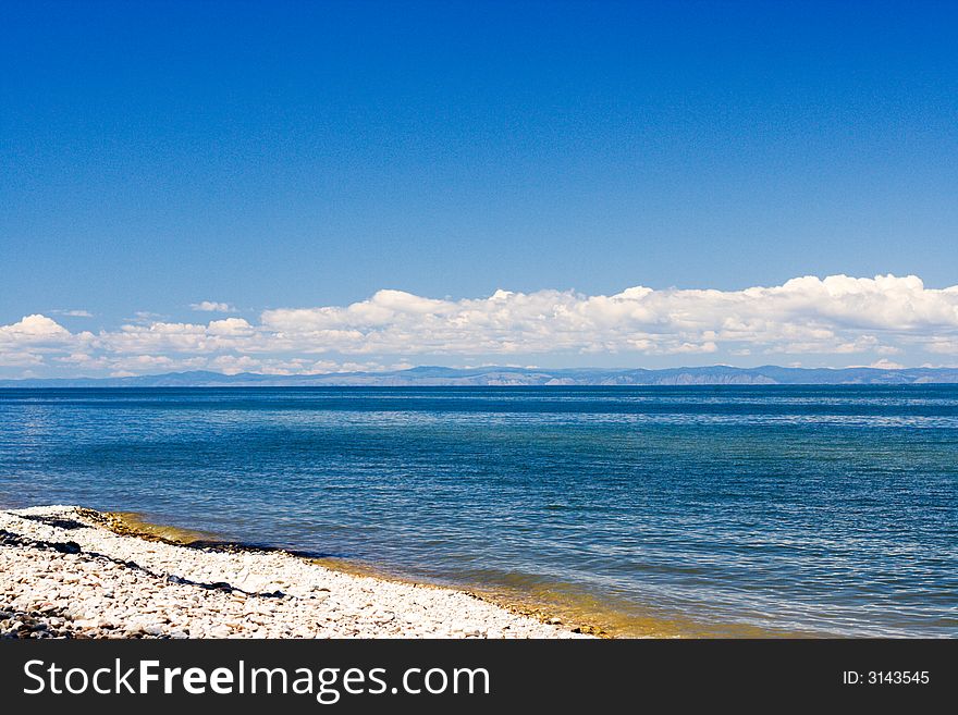 Baikal lakeside with mountains of Olhon island on skyline (lake Baikal - first-rate reservoir of unadulterated sweet water, it contains about 1/4 of all world's reserve)